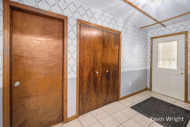 tiled foyer with a chandelier