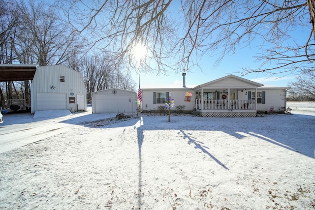 view of front of property featuring an outbuilding, covered porch, a garage, and a carport