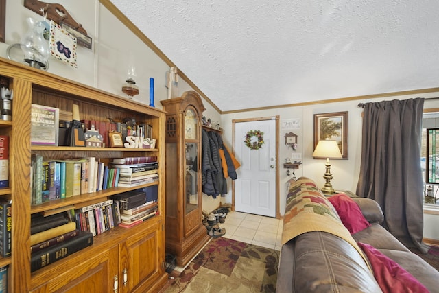 tiled entrance foyer featuring a textured ceiling and ornamental molding