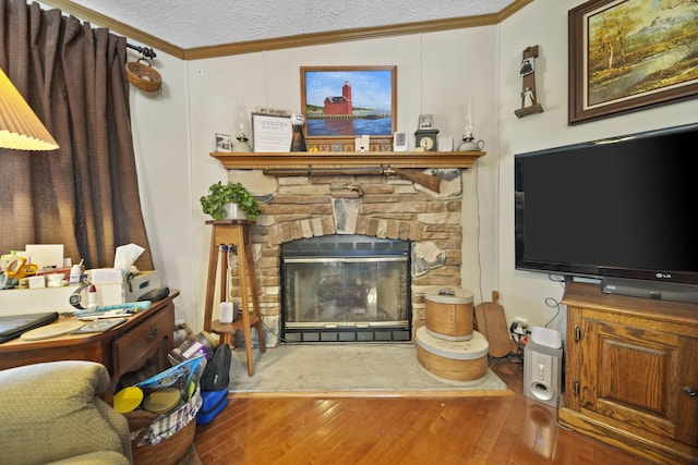 living room with a textured ceiling, wood-type flooring, a fireplace, and ornamental molding