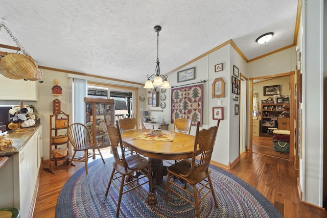 dining room featuring hardwood / wood-style floors, a notable chandelier, and lofted ceiling