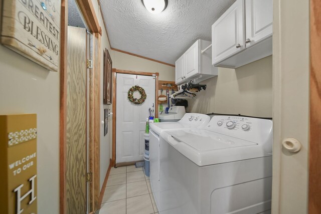 clothes washing area with cabinets, a textured ceiling, washing machine and dryer, and ornamental molding