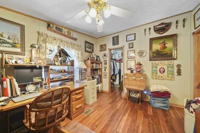 office space with hardwood / wood-style floors, a textured ceiling, ceiling fan, and crown molding