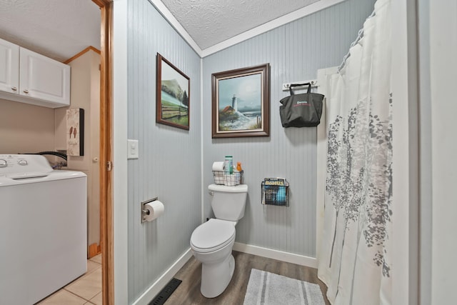 bathroom featuring hardwood / wood-style floors, crown molding, toilet, a textured ceiling, and washer / dryer