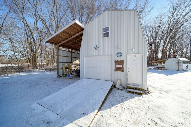 snow covered garage featuring a carport