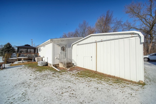 snow covered back of property with a gazebo