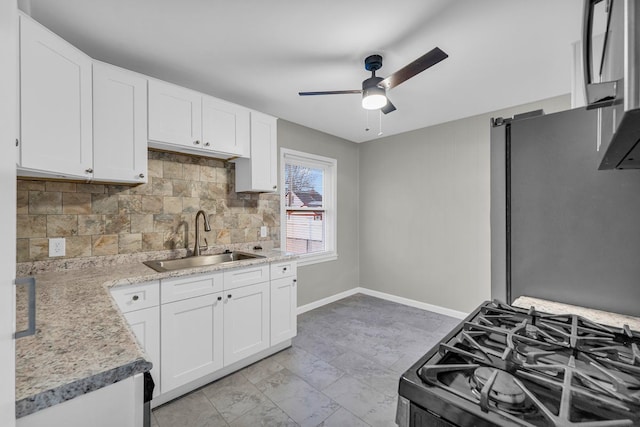 kitchen with sink, white cabinets, and stove