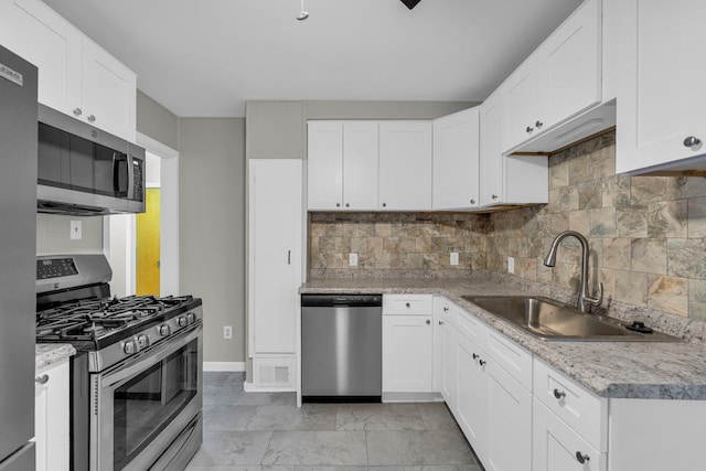 kitchen featuring white cabinets, appliances with stainless steel finishes, backsplash, and sink