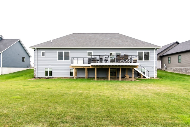 rear view of house featuring a lawn and a deck