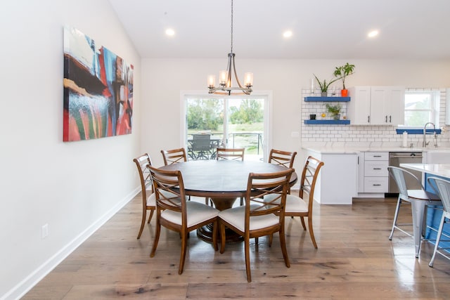 dining space with wood-type flooring and a notable chandelier