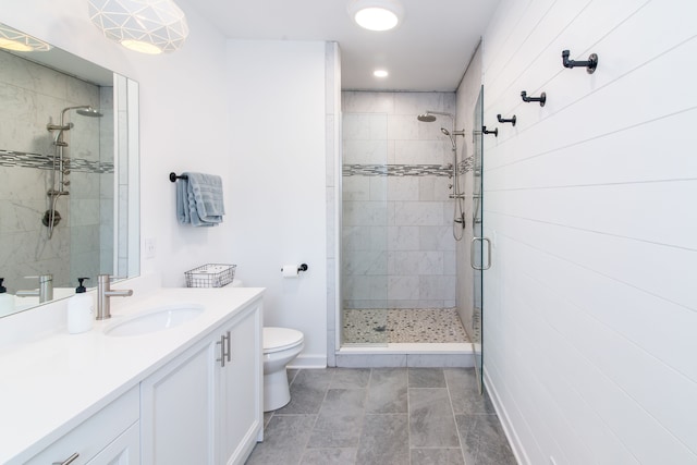 bathroom with a shower with door, vanity, and toilet