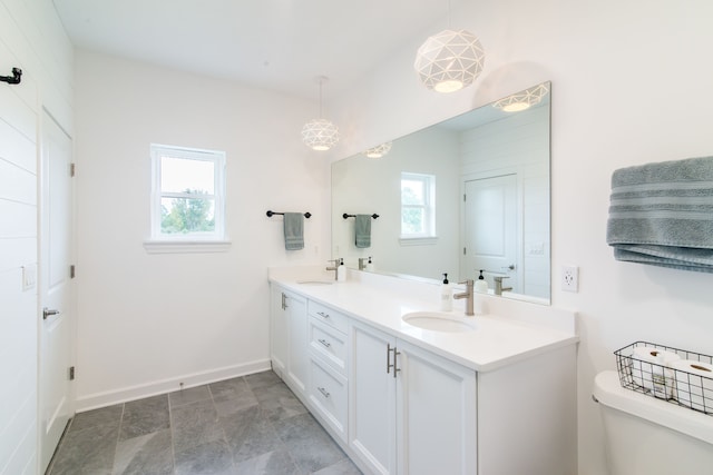 bathroom featuring vanity, a healthy amount of sunlight, and toilet