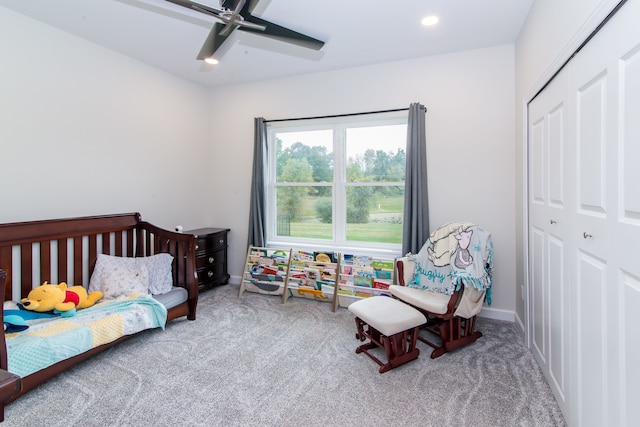 bedroom featuring ceiling fan, a closet, and light carpet