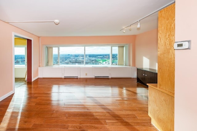 empty room with hardwood / wood-style flooring and a healthy amount of sunlight