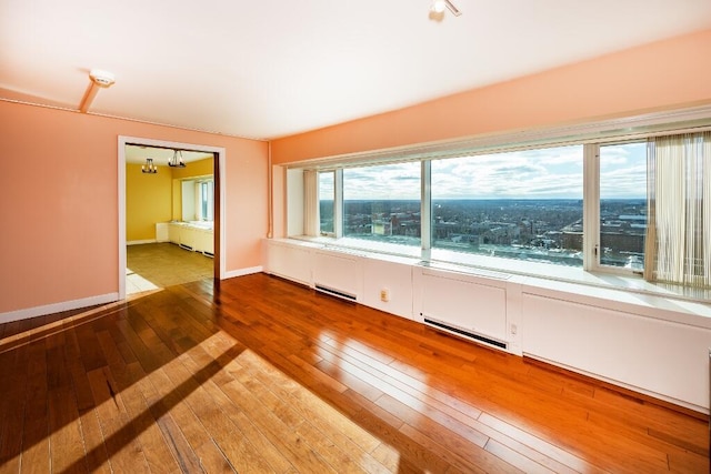 unfurnished room featuring a notable chandelier and wood-type flooring