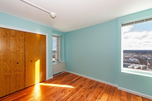 unfurnished bedroom with a closet and hardwood / wood-style floors