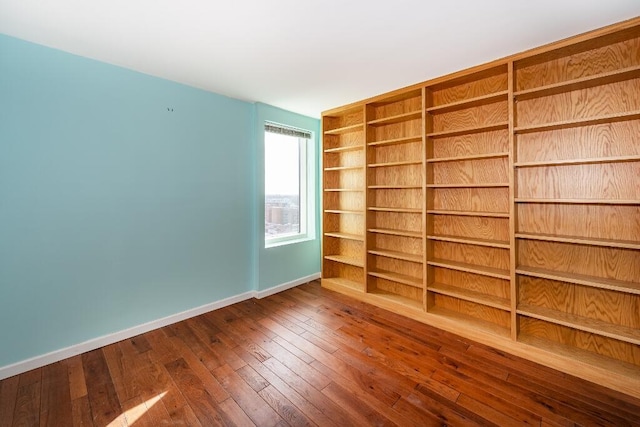 empty room with built in features and wood-type flooring