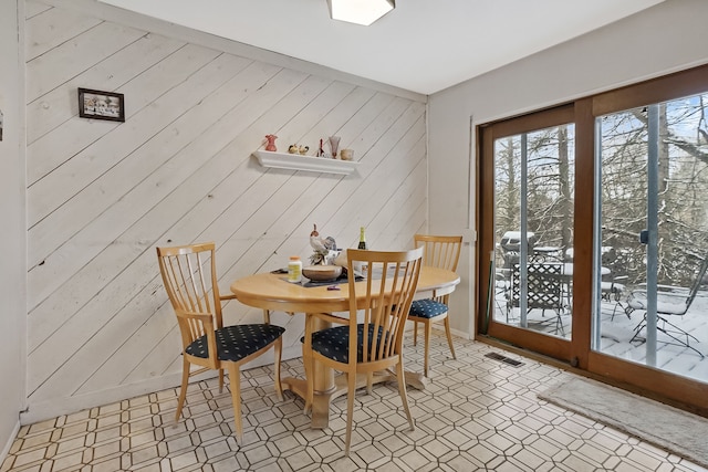 dining space with wood walls