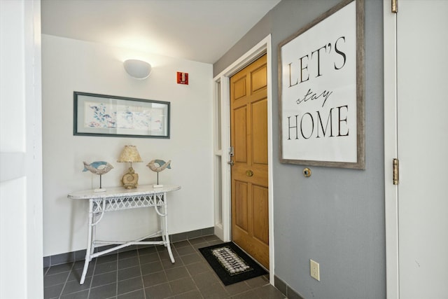 entryway with dark tile patterned flooring
