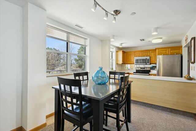 dining space featuring light colored carpet
