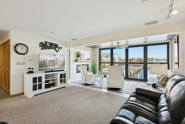 carpeted living room with ceiling fan and track lighting