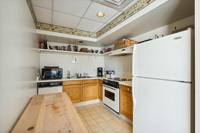 kitchen with sink, wooden counters, extractor fan, white appliances, and a paneled ceiling