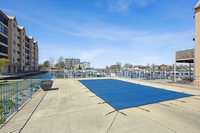 view of pool featuring a water view and a patio