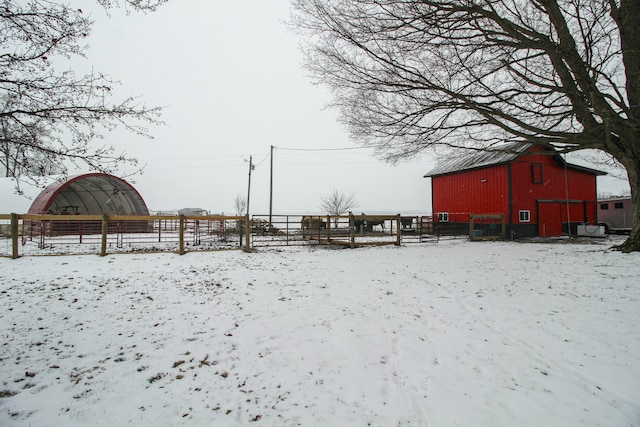 yard layered in snow with an outbuilding