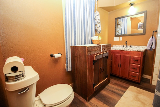 bathroom featuring hardwood / wood-style flooring, vanity, and toilet