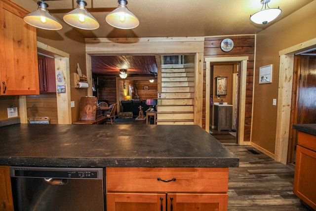 kitchen with dishwasher, pendant lighting, dark hardwood / wood-style flooring, and wood walls