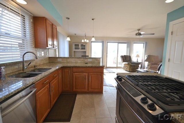 kitchen featuring backsplash, sink, decorative light fixtures, kitchen peninsula, and stainless steel appliances