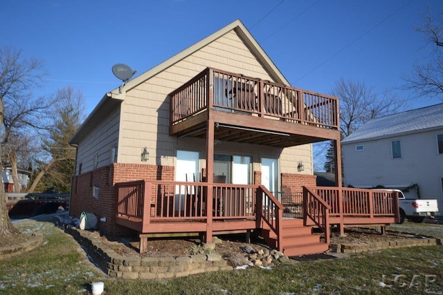 rear view of house featuring a balcony and a deck