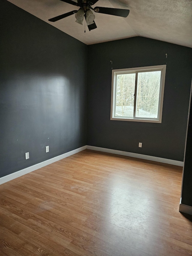 unfurnished room featuring ceiling fan, lofted ceiling, and light hardwood / wood-style flooring