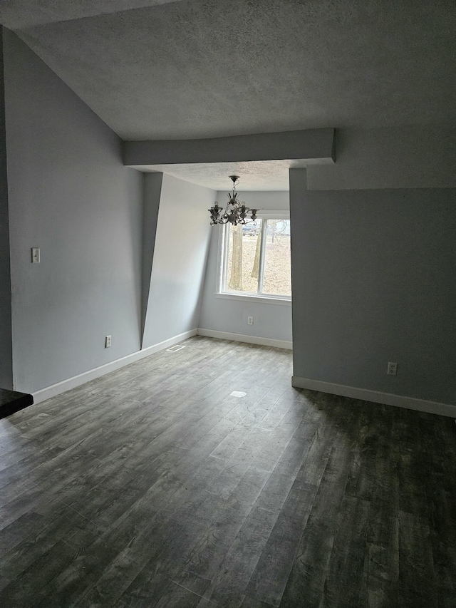 spare room with a textured ceiling and a notable chandelier