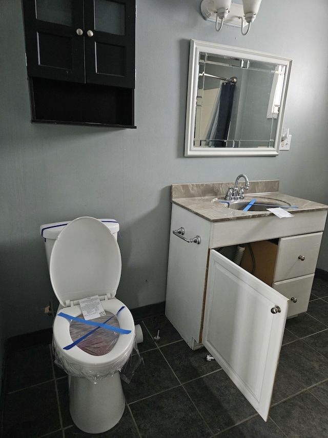 bathroom featuring tile patterned flooring, vanity, and toilet