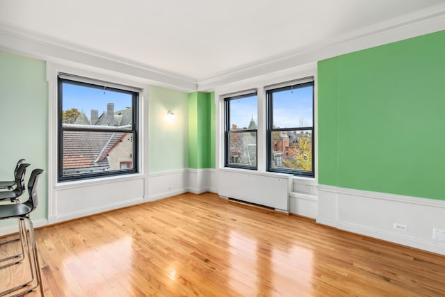 unfurnished room with light hardwood / wood-style floors and ornamental molding