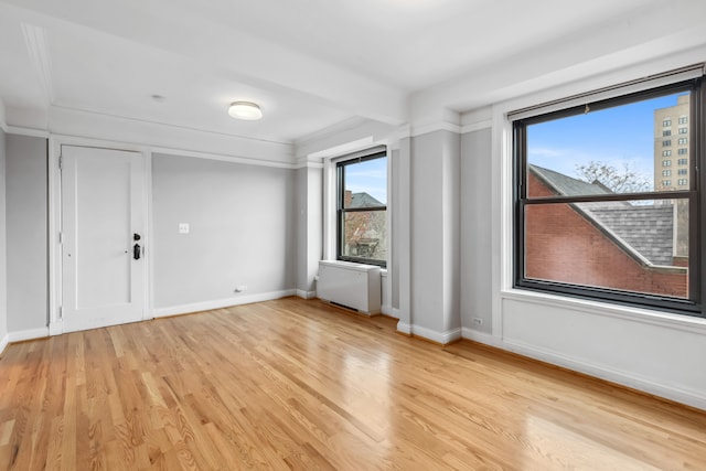 interior space with crown molding, radiator heating unit, and light hardwood / wood-style flooring