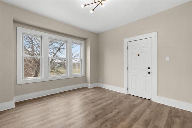 foyer with light hardwood / wood-style floors and a notable chandelier