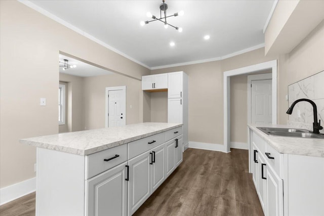 kitchen with a kitchen island, white cabinetry, dark wood-type flooring, and sink