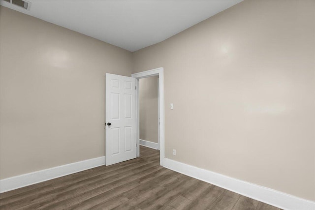 unfurnished room with dark wood-type flooring