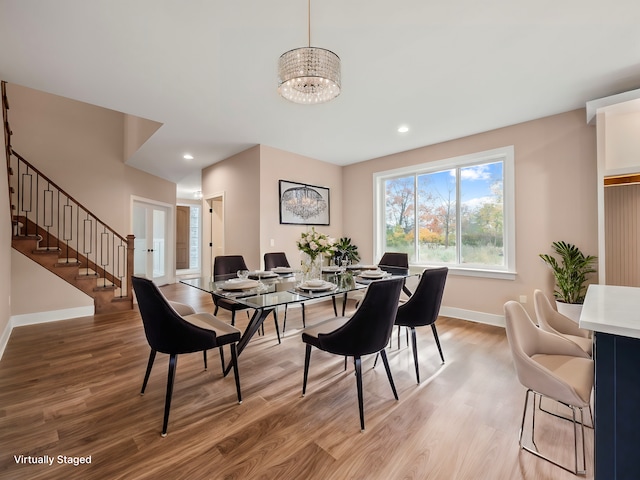 dining space with a chandelier and light hardwood / wood-style flooring