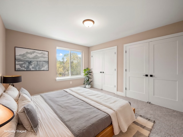 bedroom featuring carpet floors and two closets