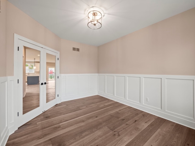 spare room featuring french doors and dark hardwood / wood-style flooring