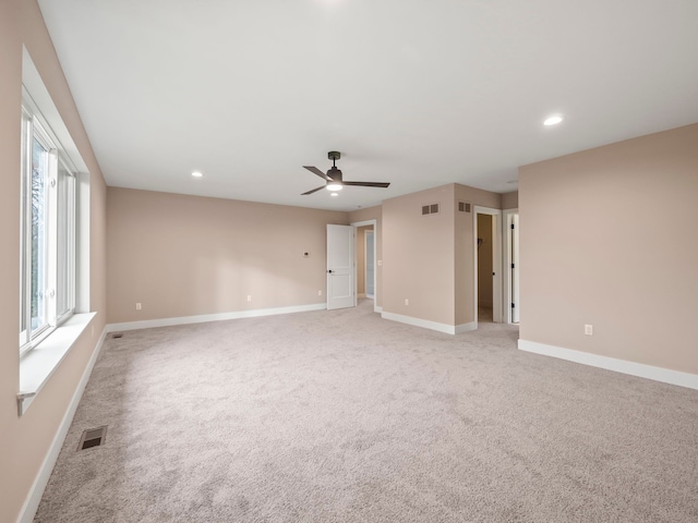 spare room featuring ceiling fan and light colored carpet