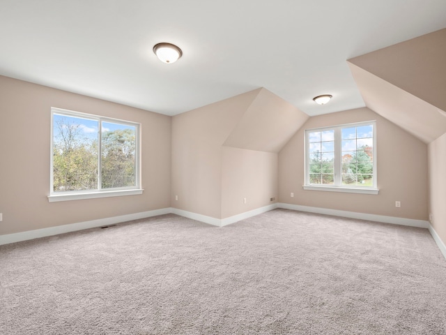 bonus room with carpet floors, vaulted ceiling, and a wealth of natural light