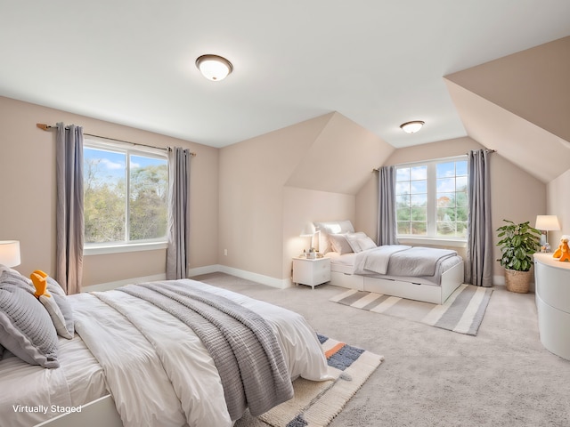 bedroom with light carpet, multiple windows, and lofted ceiling