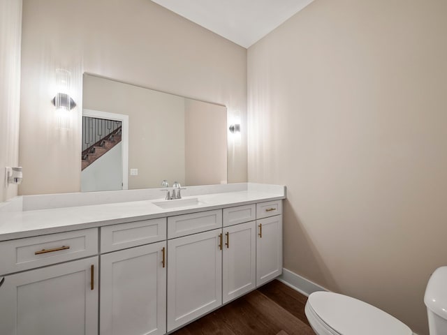 bathroom featuring hardwood / wood-style floors, vanity, and toilet