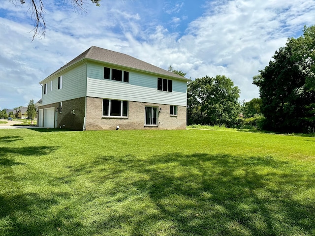 back of property featuring a yard and a garage