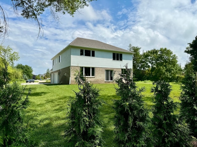 rear view of house featuring a yard and a garage