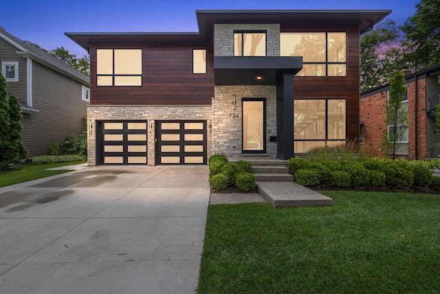 contemporary home featuring a garage and a front lawn